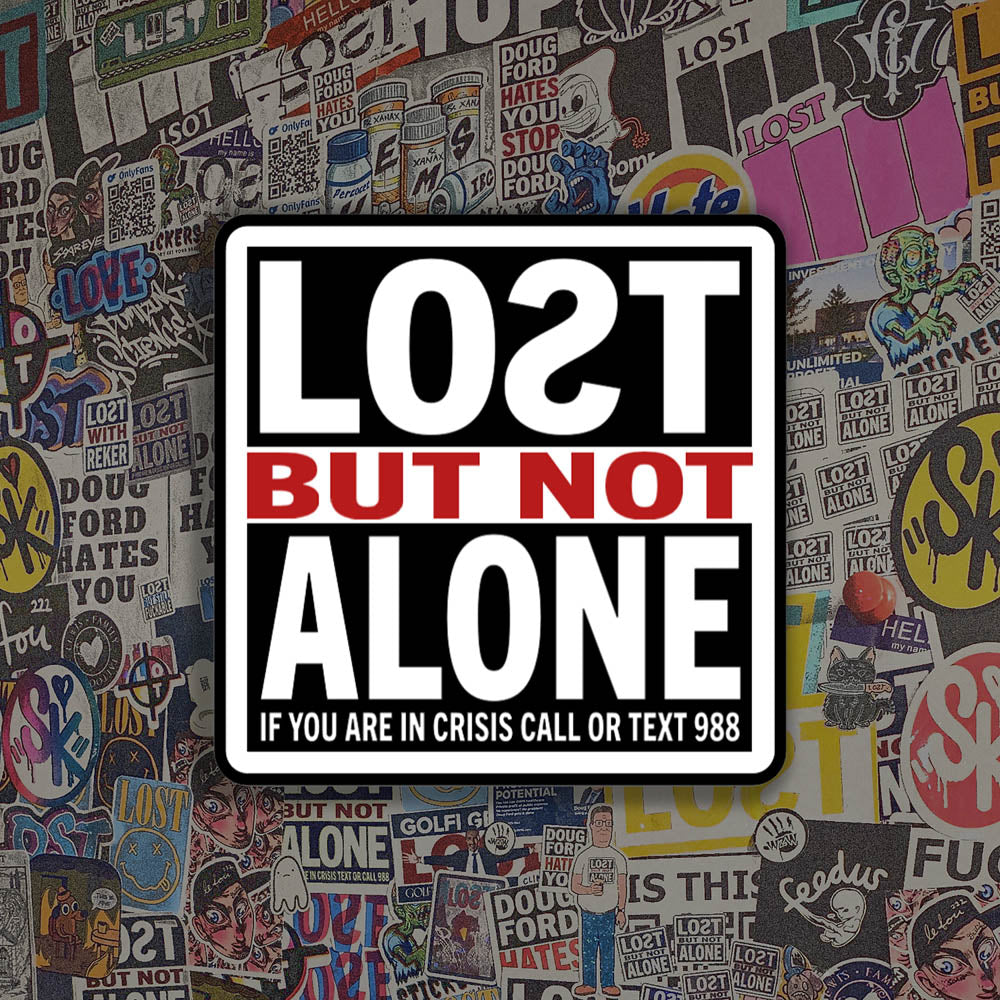 The Lost But Not Alone Sticker by artist and mental health advocate Christopher Reilly. This squared sticker features text stating Lost But Not Alone, if you are in crisis call or text 988. The black, white and red sticker design promotes mental health awareness and suicide prevention. A collection of colorful graffiti stickers by artists from around the world makes up the background.