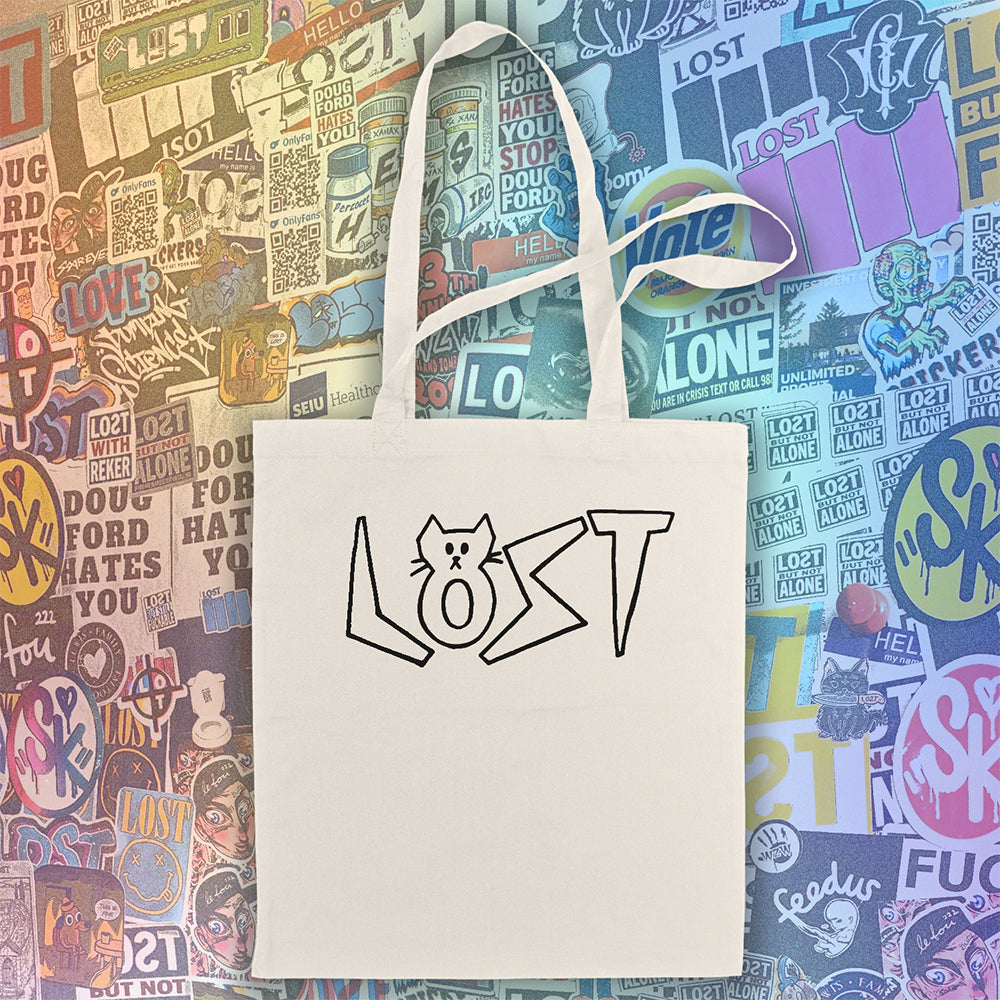 Cat shaped spell out the word LOST across a large tote bag. Hand drawn my my daughter Charlotte and printed in black on natural canvas tote bags. An assortment of colorful graffiti stickers makes up the display background.